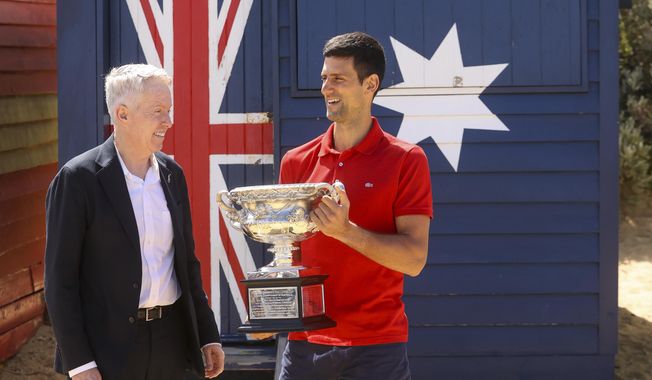 Serbia&#x27;s Novak Djokovic, right, stands with Australian Open tournament director Craig Tiley for a trophy photo shoot following his win the Australian Open tennis championships in Melbourne, Australia, Monday, Feb 22, 2021. The No. 1-ranked Djokovic was denied entry at the Melbourne airport late Wednesday, Jan 5, 2022, after border officials canceled his visa for failing to meet its entry requirement that all noncitizens be fully vaccinated for COVID-19. (AP Photo/Hamish Blair) ** FILE **