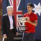 Serbia&#39;s Novak Djokovic, right, stands with Australian Open tournament director Craig Tiley for a trophy photo shoot following his win the Australian Open tennis championships in Melbourne, Australia, Monday, Feb 22, 2021. The No. 1-ranked Djokovic was denied entry at the Melbourne airport late Wednesday, Jan 5, 2022, after border officials canceled his visa for failing to meet its entry requirement that all noncitizens be fully vaccinated for COVID-19. (AP Photo/Hamish Blair) ** FILE **