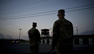 In this June 5, 2018 photo, reviewed by U.S. military officials, troops stand guard outside Camp Delta at the Guantanamo Bay detention center, in Cuba. The 20th anniversary of the first prisoners&#39; arrival at the Guantanamo Bay detention center is on Tuesday, Jan. 11, 2022. There are now 39 prisoners left. At its peak, in 2003, the detention center held nearly 680 prisoners. (AP Photo/Ramon Espinosa, File)