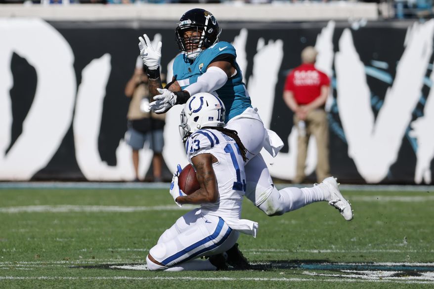 Indianapolis Colts wide receiver T.Y. Hilton (13) catches a pass in front of Jacksonville Jaguars middle linebacker Damien Wilson during the first half of an NFL football game, Sunday, Jan. 9, 2022, in Jacksonville, Fla. (AP Photo/Stephen B. Morton)