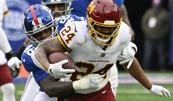 Washington Football Team running back Antonio Gibson (24) is tackled by New York Giants inside linebacker Tae Crowder (48) during the second quarter of an NFL football game, Saturday, Jan. 9, 2021, in East Rutherford, N.J. (AP Photo/Bill Kostroun)