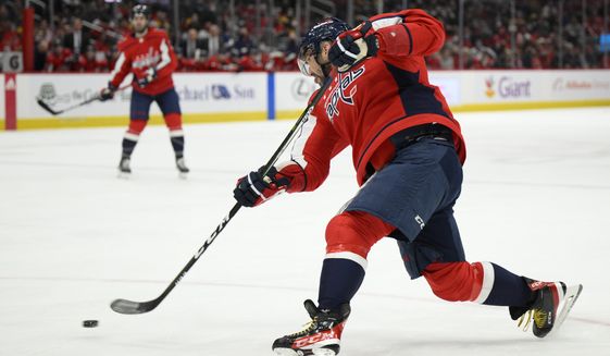 Washington Capitals left wing Alex Ovechkin (8) shoots during the first period of an NHL hockey game against the Boston Bruins, Monday, Jan. 10, 2022, in Washington. (AP Photo/Nick Wass)