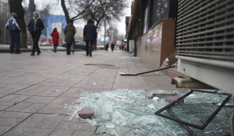 People walk past a shop with windows broken during clashes in Almaty, Kazakhstan, Monday, Jan. 10, 2022. Kazakhstan&#39;s health ministry says over 150 people have been killed in protests that have rocked the country over the past week. President Kassym-Jomart Tokayev&#39;s office said Sunday that order has stabilized in the country and that authorities have regained control of administrative buildings that were occupied by protesters, some of which were set on fire. (Vladimir Tretyakov/NUR.KZ via AP)