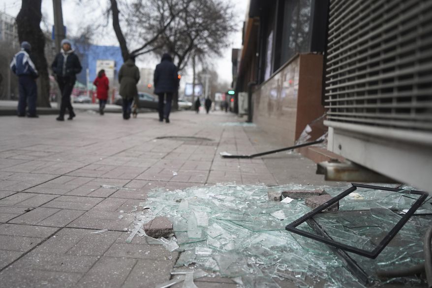 People walk past a shop with windows broken during clashes in Almaty, Kazakhstan, Monday, Jan. 10, 2022. Kazakhstan&#x27;s health ministry says over 150 people have been killed in protests that have rocked the country over the past week. President Kassym-Jomart Tokayev&#x27;s office said Sunday that order has stabilized in the country and that authorities have regained control of administrative buildings that were occupied by protesters, some of which were set on fire. (Vladimir Tretyakov/NUR.KZ via AP)