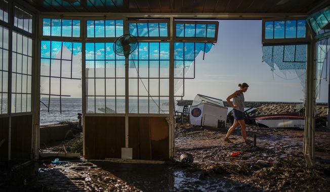 Carla Bayerri, 45, inspects her restaurant after flooding in the seaside town of Alcanar, in northeastern Spain, Sept. 2, 2021. Damage wrought by Hurricane Ida in the U.S. state of Louisiana and the flash floods that hit Europe last summer have helped make 2021 one of the most expensive years for natural disasters. Reinsurance company Munich Re said Monday, Jan. 10, 2022 that overall economic losses from natural disasters worldwide last year reached $280 billion. (AP Photo/Joan Mateu Parra, file)
