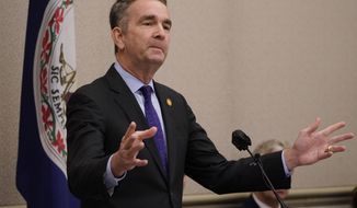 Virginia Gov. Ralph Northam gestures as he delivers his annual budget forecast to a joint session of the House and Senate budget committees at the Capitol Thursday Dec 16, 2021, in Richmond, Va. (AP Photo/Steve Helber)