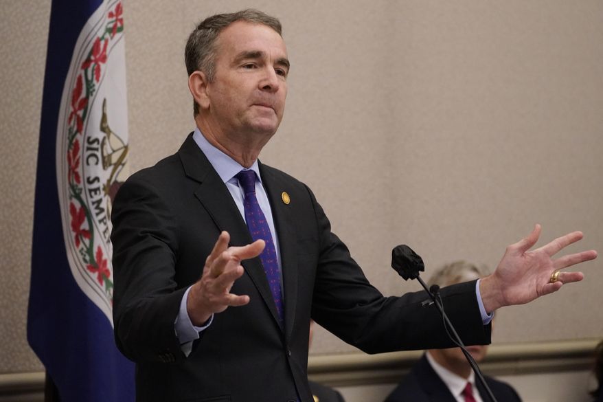 Virginia Gov. Ralph Northam gestures as he delivers his annual budget forecast to a joint session of the House and Senate budget committees at the Capitol Thursday Dec 16, 2021, in Richmond, Va. (AP Photo/Steve Helber)