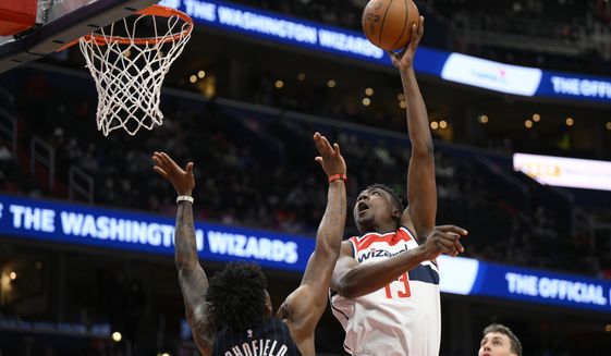 Washington Wizards center Thomas Bryant (13) shoots over Orlando Magic forward Admiral Schofield (25) during the second half of an NBA basketball game, Wednesday, Jan. 12, 2022, in Washington. The Wizards won 112-106. (AP Photo/Nick Wass)