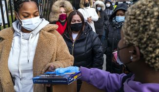 People line up and receive test kits to detect COVID-19 as they are distributed in New York on Dec. 23, 2021. The COVID-19 surge caused by the omicron variant means once-reliable indicators of the pandemic&#39;s progress are much less so, complicating how the media is able to tell the story. (AP Photo/Craig Ruttle, File)