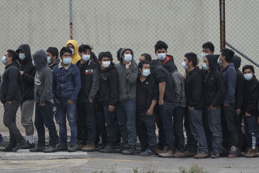 Guatemalans deported from McAllen, Texas, watch soldiers carry a coffin containing the remains of a migrant killed in a truck crash in southern Mexico, after deplaning at La Aurora International Airport in Guatemala City, Thursday, Jan. 13, 2022. Dozens of people were killed and scores injured when a truck carrying Central American migrants rolled over on a highway in Tuxtla, Mexico on Dec. 9. (AP Photo/Moises Castillo)