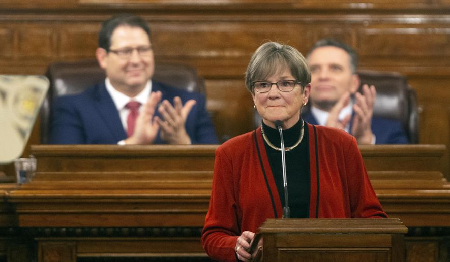 Gov. Laura Kelly is applauded as she begins addressing the Kansas Legislature for the annual State of the State, Tuesday, Jan. 11, 2022, in Topeka, Kan. Democratic and Republican governors are taking vastly different approaches to addressing the ongoing pandemic in their state of the state speeches.   (Evert Nelson/The Topeka Capital-Journal via AP)