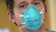 Registered nurse Scott McGieson wears an N95 mask as he walks out of a patient&#39;s room in the acute care unit of Harborview Medical Center, Friday, Jan. 14, 2022, in Seattle. (AP Photo/Elaine Thompson) ** FILE **