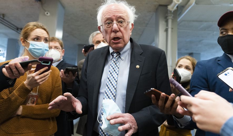 Sen. Bernie Sanders, I-Vt., makes comments to reporters about Sen. Joe Manchin, D-W.Va., as he walks to the Senate Chamber for a vote, on Dec. 15, 2021, in Washington. Just over a year ago, millions of energized young people, women, voters of color and independents joined forces to send Joe Biden to the White House. But 12 months after he entered the Oval Office, many describe a coalition in crisis.(AP Photo/Jacquelyn Martin, File)