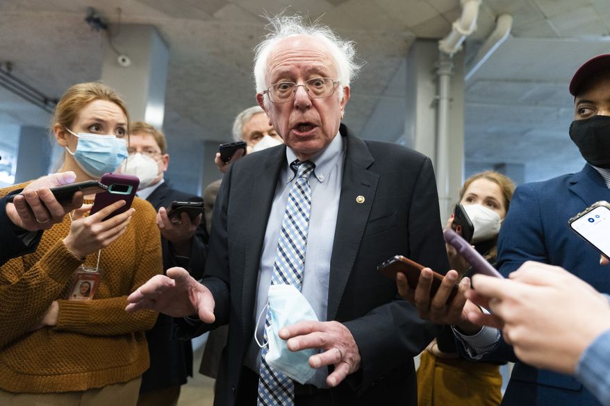 Sen. Bernie Sanders, I-Vt., makes comments to reporters about Sen. Joe Manchin, D-W.Va., as he walks to the Senate Chamber for a vote, on Dec. 15, 2021, in Washington. Just over a year ago, millions of energized young people, women, voters of color and independents joined forces to send Joe Biden to the White House. But 12 months after he entered the Oval Office, many describe a coalition in crisis.(AP Photo/Jacquelyn Martin, File)