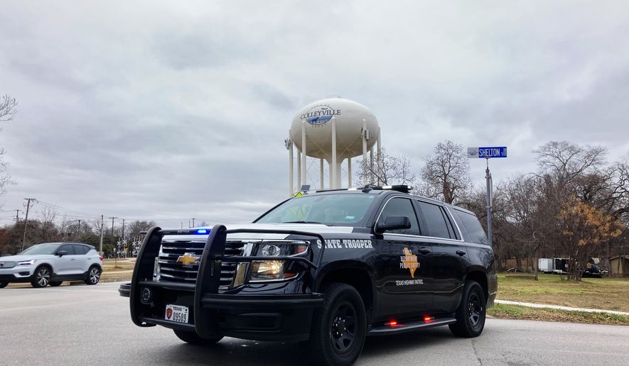 A Texas state trooper blocks traffic on a road leading to a Colleyville, Texas, synagogue where a man apparently took hostages, Saturday, Jan. 15, 2022. (AP Photo/Jake Bleiberg)