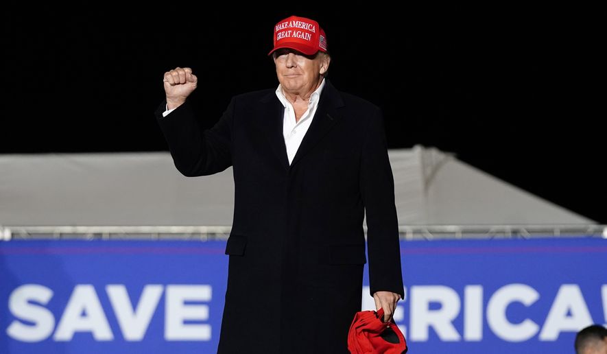 Former President Donald Trump gives a fist pump to the crowd as he arrives to speak at a rally, Saturday, Jan. 15, 2022, in Florence, Ariz. (AP Photo/Ross D. Franklin)