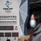 A woman wearing a face mask to protect against COVID-19 walks past a clock counting down the time until the opening ceremony of the 2022 Winter Olympics in Beijing, Saturday, Jan. 15, 2022. As the Beijing Winter Olympics loom, the Chinese capital is stepping measures to keep the coronavirus at bay including suspending most access to Tianjin, an adjacent major city which is dealing with an outbreak of the highly contagious omicron variant. These outbreaks are posing a test to its &amp;quot;zero-tolerance&amp;quot; COVID-19 policy and its ability to successfully host the Winter Olympics. (AP Photo/Mark Schiefelbein)