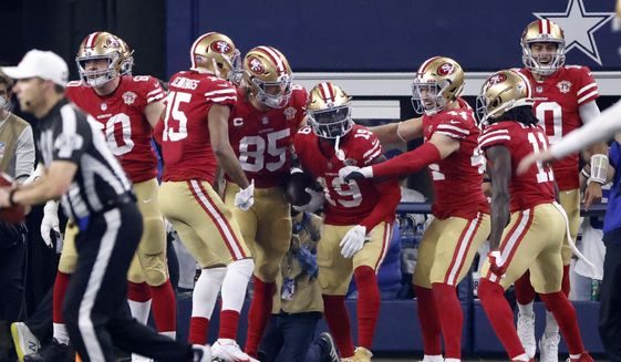 San Francisco 49ers&#39; Jauan Jennings (15), George Kittle (85), Kyle Juszczyk (44), Brandon Aiyuk (11) and Jimmy Garoppolo, right, celebrate with Deebo Samuel (19) after his touchdown catch in the second half of an NFL wild-card playoff football game in Arlington, Texas, Sunday, Jan. 16, 2022. (AP Photo/Ron Jenkins)
