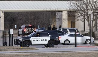 Police stand in front of the Congregation Beth Israel synagogue, Sunday, Jan. 16, 2022, in Colleyville, Texas. A man held hostages for more than 10 hours Saturday inside the temple. The hostages were able to escape and the hostage taker was killed. FBI Special Agent in Charge Matt DeSarno said a team would investigate &quot;the shooting incident.&quot; (AP Photo/Brandon Wade)