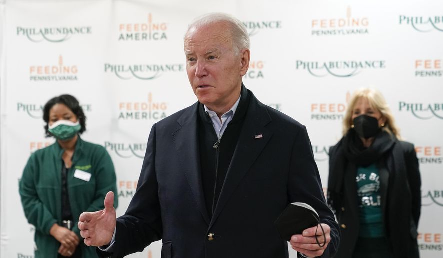 President Joe Biden speaks with members of the press about the Texas synagogue hostage incident before volunteering with first lady Jill Biden, back right, at hunger relief organization Philabundance, Sunday, Jan. 16, 2022, in Philadelphia. (AP Photo/Patrick Semansky)