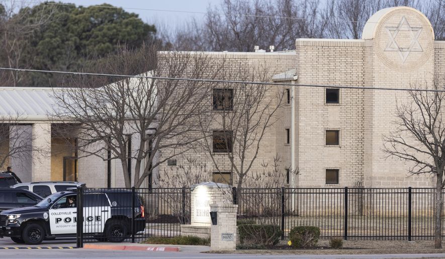 Police stand in front of the Congregation Beth Israel synagogue, Sunday, Jan. 16, 2022, in Colleyville, Texas. A man held hostages for more than 10 hours Saturday inside the temple. The hostages were able to escape and the hostage taker was killed. FBI Special Agent in Charge Matt DeSarno said a team would investigate &quot;the shooting incident.&quot; (AP Photo/Brandon Wade)