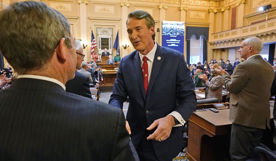 Virginia Gov. Glenn Youngkin, center, shakes the hand of State Sen. John Cosgrove, R-Chesapeake, after he delivered his State of the Commonwealth address before a joint session of the Virginia General Assembly in the House chambers at the Capitol Monday Jan. 17, 2022, in Richmond, Va. (AP Photo/Steve Helber)