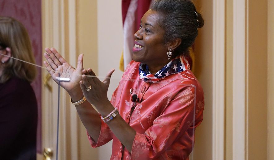 Virginia Lt. Gov. Winsome Earle-Sears applauds visitors as she presides at the Capitol Monday Jan. 17, 2022, in Richmond, Va. (AP Photo/Steve Helber)
