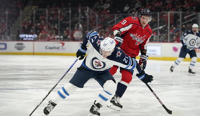 Winnipeg Jets left wing Nikolaj Ehlers (27) tries to maintain possession as he is pressured by Washington Capitals defenseman Dmitry Orlov in the first period of an NHL hockey game, Tuesday, Jan. 18, 2022, in Washington. (AP Photo/Patrick Semansky) **FILE**
