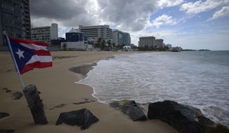 A Puerto Rican flag flies on an empty beach at Ocean Park, in San Juan, Puerto Rico, Thursday, May 21, 2020.  Puerto Rico’s nearly five-year bankruptcy battle was resolved Tuesday, Jan. 18, 2022, after a federal judge signed a plan that slashes the U.S. territory’s public debt load as part of a restructuring and allows the government to start repaying creditors. (AP Photo/Carlos Giusti, File)