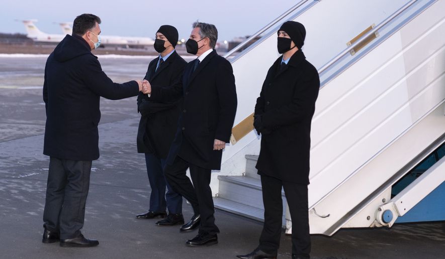Secretary of State Antony Blinken, second from right, is greeted by Ukrainian Deputy Foreign Minister Dmytro Senik, left, as he arrives at the Boryspil International Airport, Wednesday, Jan. 19, 2022, in Kyiv, Ukraine. (AP Photo/Alex Brandon, Pool)