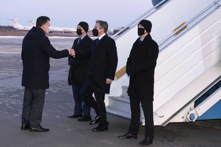 Secretary of State Antony Blinken, second from right, is greeted by Ukrainian Deputy Foreign Minister Dmytro Senik, left, as he arrives at the Boryspil International Airport, Wednesday, Jan. 19, 2022, in Kyiv, Ukraine. (AP Photo/Alex Brandon, Pool)
