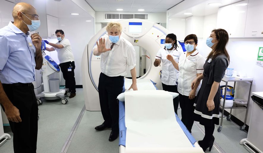 Britain&#39;s Prime Minister Boris Johnson, centre, gestures, during a visit to Finchley Memorial Hospital, in North London, Tuesday, Jan. 18, 2022. (Ian Vogler, Pool Photo via AP)