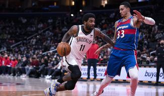 Brooklyn Nets guard Kyrie Irving (11) drives to the basket against Washington Wizards forward Kyle Kuzma (33) during the first half of an NBA basketball game Wednesday, Jan. 19, 2022, in Washington. (AP Photo/Evan Vucci)