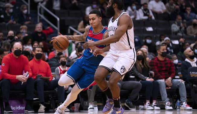 Brooklyn Nets guard James Harden, right, defends against Washington Wizards forward Kyle Kuzma during the first half of an NBA basketball game Wednesday, Jan. 19, 2022, in Washington. (AP Photo/Evan Vucci)