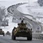 A convoy of Russian armored vehicles moves along a highway in Crimea, Tuesday, Jan. 18, 2022. Russia has concentrated an estimated 100,000 troops with tanks and other heavy weapons near Ukraine in what the West fears could be a prelude to an invasion. (AP Photo)