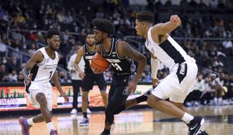 Georgetown&#39;s Kaiden Rice (11) drives to the basket as Providence&#39;s Al Durham (1) and Ed Croswell, right, defend during the second half of an NCAA college basketball game Thursday, Jan. 20, 2022, in Providence, R.I. (AP Photo/Stew Milne)