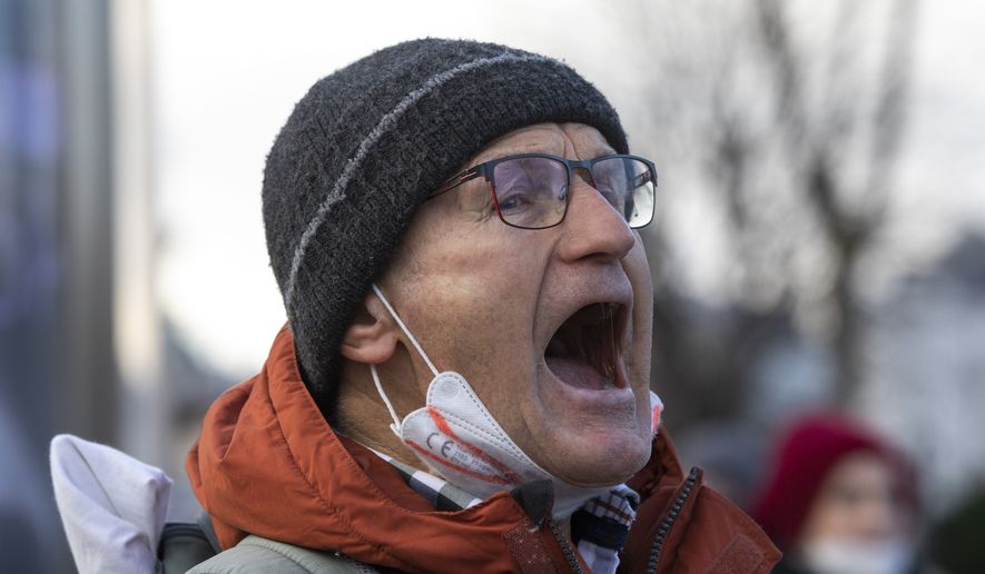 A man protests on the street against the compulsory COVID-19 vaccination that will be decided in the parliament today in Vienna, Austria, Thursday, Jan. 20, 2022. (AP Photo/Lisa Leutner)