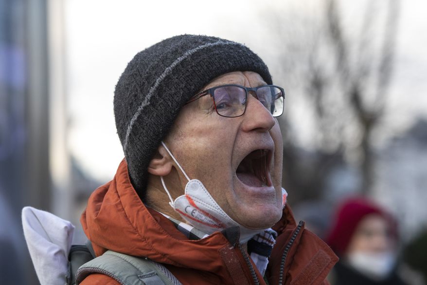 A man protests on the street against the compulsory COVID-19 vaccination that will be decided in the parliament today in Vienna, Austria, Thursday, Jan. 20, 2022. (AP Photo/Lisa Leutner)