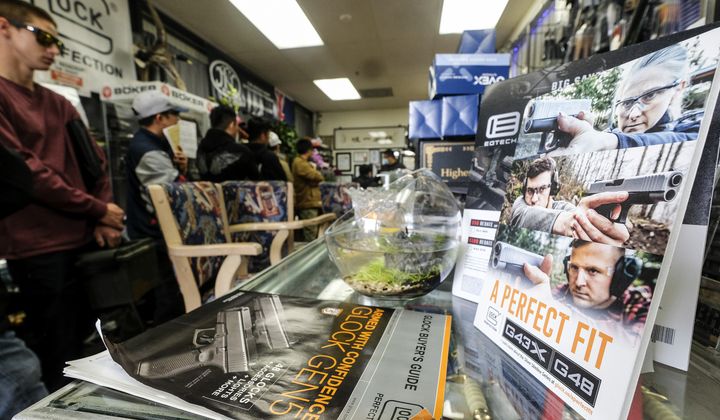 People wait in a line at a gun at store amid merchandise displays, in Arcadia, Calif., on Sunday, March 15, 2020. (AP Photo/Ringo H.W. Chiu) **FILE**