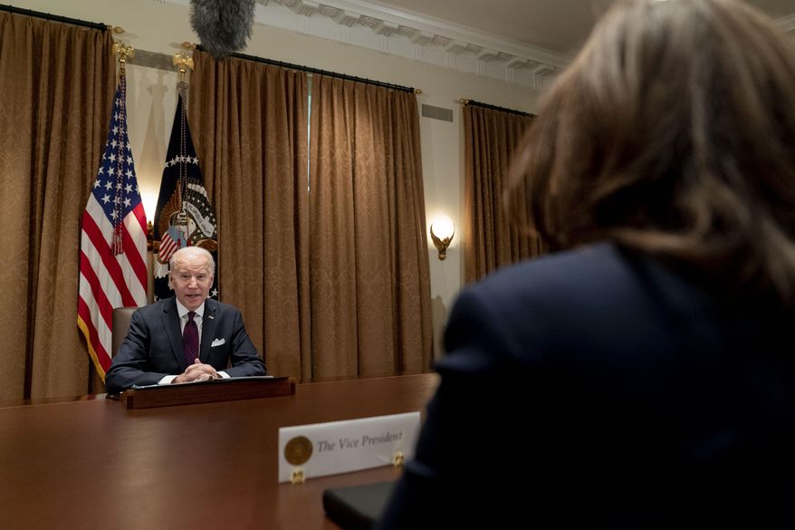 President Joe Biden, accompanied by Vice President Kamala Harris, right, speaks as he meets with members of the Infrastructure Implementation Task Force to discuss the Bipartisan Infrastructure Law, in the Cabinet Room at the White House in Washington, Thursday, Jan. 20, 2022. (AP Photo/Andrew Harnik)