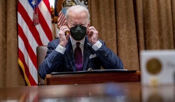 President Joe Biden puts on his mask during a meeting with members of the Infrastructure Implementation Task Force to discuss the Bipartisan Infrastructure Law, in the Cabinet Room of the White House in Washington, Thursday, Jan. 20, 2022. (AP Photo/Andrew Harnik)