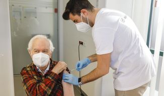 Kurt Switil, left, receives a Pfizer vaccination against the coronavirus in Vienna, April 10, 2021. Austria&#39;s parliament is due to vote Thursday, Jan. 20, 2022, on plans to introduce a COVID-19 vaccine mandate for the adult population, the first of its kind in Europe. (AP Photo/Lisa Leutner, File)