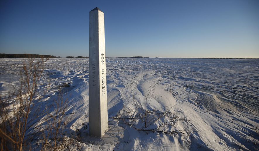A border marker, between the United States and Canada is shown just outside of Emerson, Manitoba, on Thursday, Jan. 20, 2022.  A Florida man was charged Thursday with human smuggling after the bodies of four people, including a baby and a teen, were found in Canada near the U.S. border, in what authorities believe was a failed crossing attempt during a freezing blizzard. The bodies were found Wednesday in the province of Manitoba just meters (yards) from the U.S. border near the community of Emerson. (John Woods/The Canadian Press via AP)