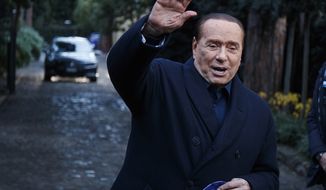 Former Italian Premier Silvio Berlusconi waves to media following a meeting with center-right leaders in Rome, on Dec. 23, 2021. Former premier Silvio Berlusconi has bowed out of Italy’s presidential election set for next week. Berlusconi, 85, said in a statement on Saturday that he had decided to “take another step on the path of national responsibility.” The media mogul insisted he had nailed down enough voters to become head of state, but he asked his supporters not to cast ballots for him. (Roberto Monaldo/LaPresse via AP, File)