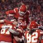 Kansas City Chiefs tight end Travis Kelce (87) celebrates with teammates after catching an 8-yard touchdown pass during overtime in an NFL divisional round playoff football game against the Buffalo Bills, Sunday, Jan. 23, 2022, in Kansas City, Mo. The Chiefs won 42-36. (AP Photo/Charlie Riedel)