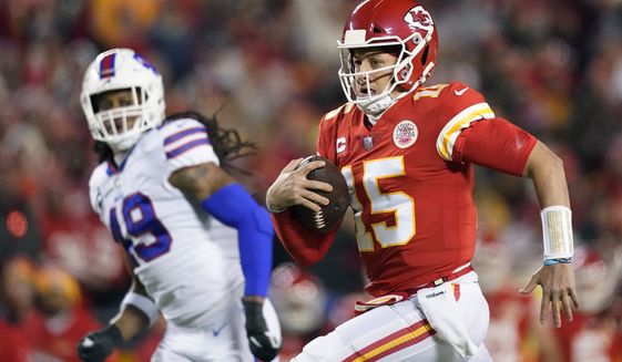 Kansas City Chiefs quarterback Patrick Mahomes (15) runs up field ahead of Buffalo Bills middle linebacker Tremaine Edmunds (49) during the first half of an NFL divisional round playoff football game, Sunday, Jan. 23, 2022, in Kansas City, Mo. (AP Photo/Charlie Riedel)