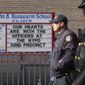 New York Police officers walk past a sign with message in support of NYPD 32nd precinct near the scene of a shooting in the Harlem neighborhood of New York, Sunday, Jan. 23, 2022. New York City Police Officer Jason Rivera was fatally shot Friday night while answering a call about an argument between a woman and her adult son. Mora and suspect Lashawn McNeil were wounded. (AP Photo/Yuki Iwamura)
