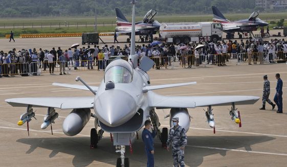 Chinese military personnel stand near a Chinese military&#39;s J-10C airplane during the 13th China International Aviation and Aerospace Exhibition, also known as Airshow China 2021, on Tuesday, Sept. 28, 2021, in Zhuhai in southern China&#39;s Guangdong province. On Sunday, Jan. 23, 2022, China flew 39 warplanes including J-10 fighter jets toward Taiwan in its largest such sortie of the new year, continuing a pattern that the island has answered by scrambling its own jets in response. (AP Photo/Ng Han Guan)