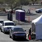 Vehicles, with patients waiting to take a COVID-19 Polymerase Chain Reaction (PCR) test, line up at a testing tent during the Federal Emergency Management Agency&#39;s drive-through COVID-19 testing site at Pima Community College West Campus in Tucson, Ariz. on Monday, Jan. 24, 2022. After a request from the Pima County Health Department, a drive-through testing site, funded by FEMA region 9, is offering free COVID-19 PCR self-swab tests from 8 a.m. to 6 p.m., Monday through Saturday. (Rebecca Sasnett/Arizona Daily Star via AP)
