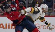 Vegas Golden Knights left wing William Carrier (28) fights for position against Washington Capitals defenseman Justin Schultz during the first period of an NHL hockey game, Monday, Jan. 24, 2022, in Washington. (AP Photo/Evan Vucci)